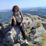 Woma on a mountain peak, sitting on a rocks